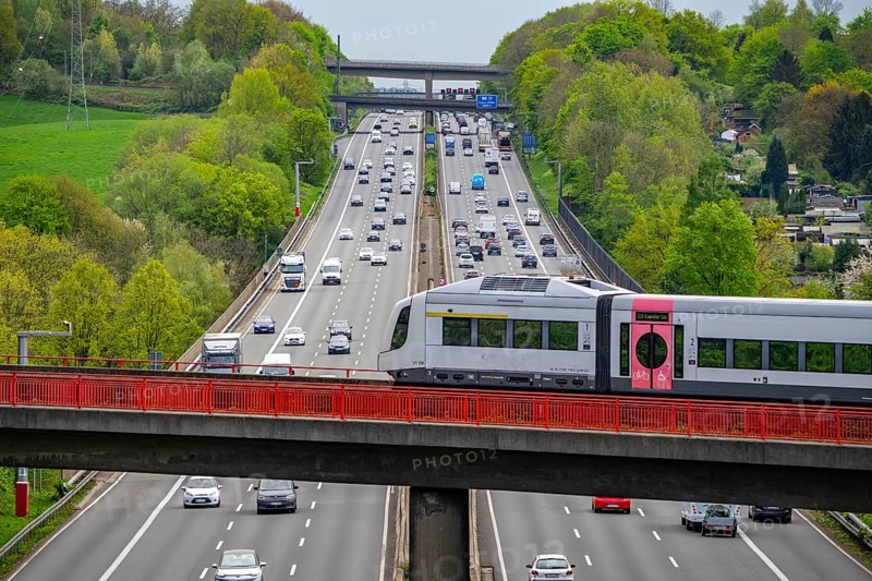 Local train S-Bahn, Regiobahn, S28, crossing the motorway A3, traffic on 8 lanes, incl. the temporarily released hard shoulder, behind the motorway junction Hilden, view in south direction, near Erkrath, North Rhine-Westphalia, Germany, Europe