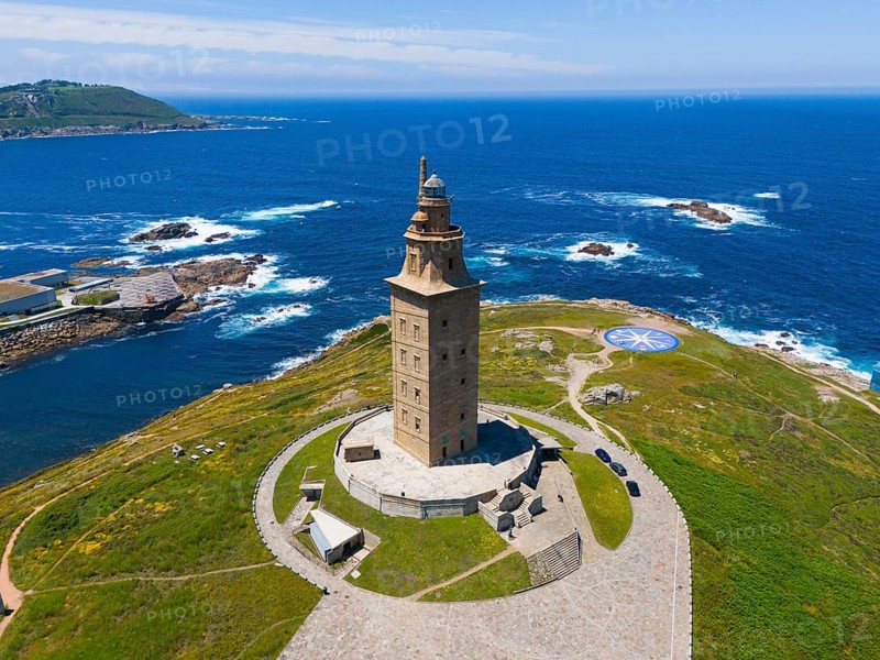 Ancient lighthouse on a land mass surrounded by crystal blue ocean and green vegetation under a clear sky, aerial view, Torre de Hércules, Torre de Hercules, Roman Tower of Hercules, A Coruna, A Coruna, La Coruna, La Coruna, Galicia, Spain, Europe