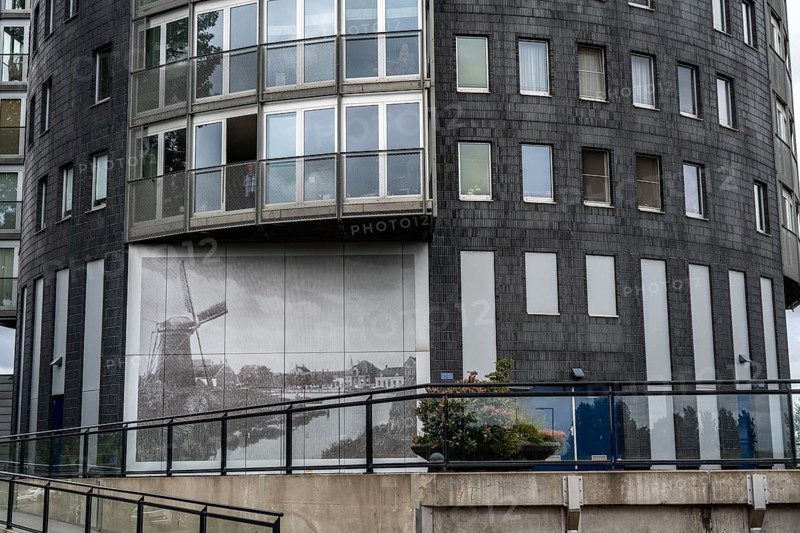 Round residential tower block, in Pernis, a town in the Europoort harbour near Rotterdam, with a mural showing what it used to look like at this location, windmill, Netherlands