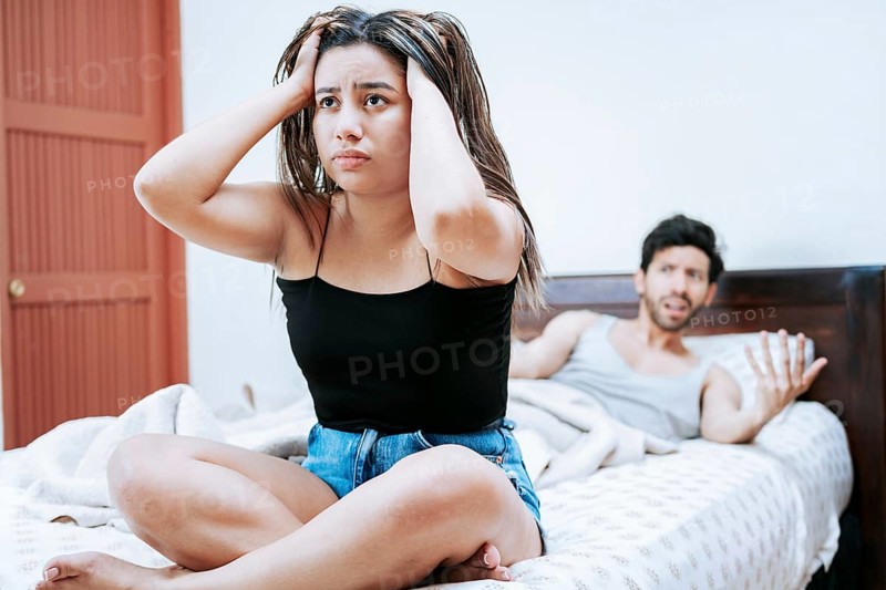 Young couple arguing sitting on the bed. Couple problems in bed. Upset woman with husband sitting on bed, Wife arguing with her husband in bed