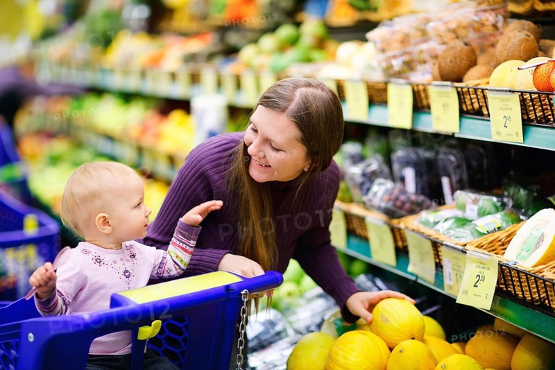 A young mother goes shopping with her baby in the supermarket, Scandinavia