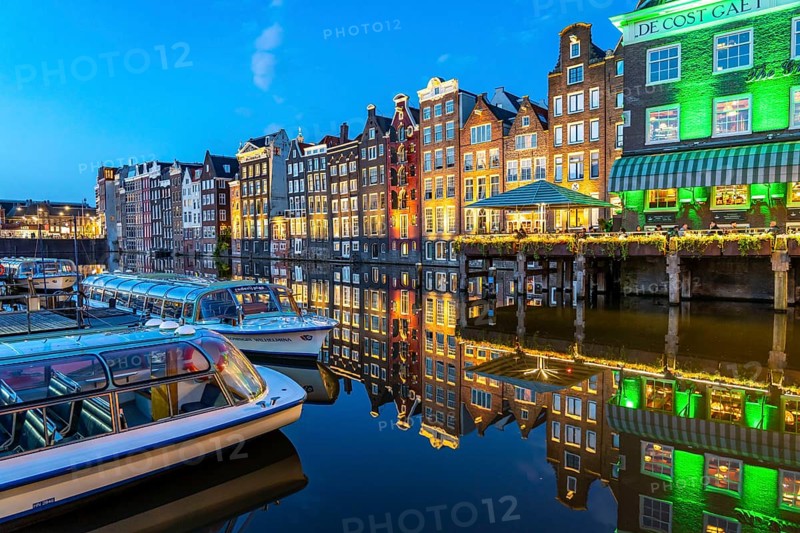 Canal houses on the Damrak, in the centre of the old town of Amsterdam, harbour, starting point of many canal tours, evening, Netherlands