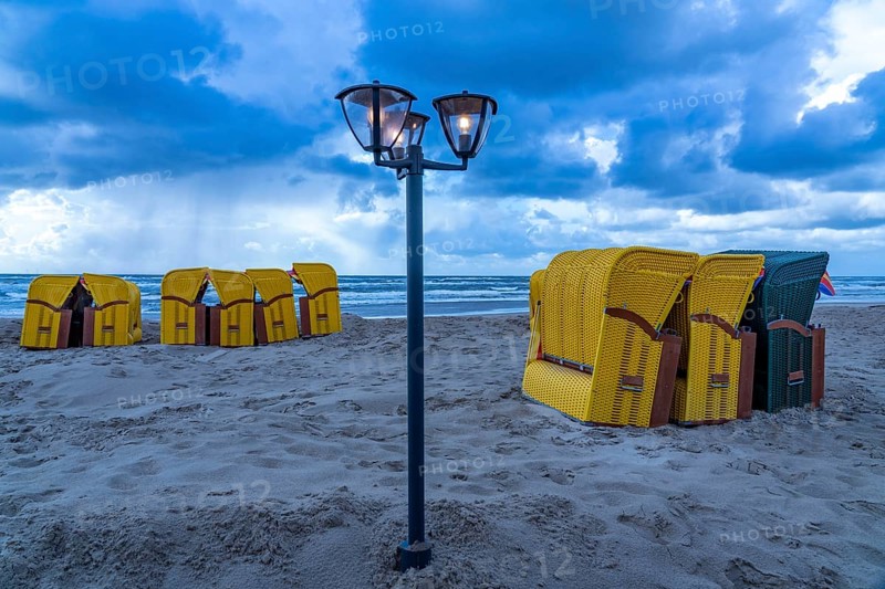 End of the season on the beach, dark storm clouds, choppy sea, autumn on the North Sea in North Holland, near Egmond aan Zee, beach chairs ready for transport to winter storage, Netherlands