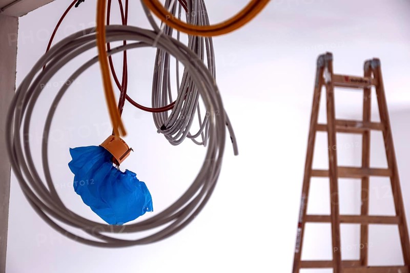 Cables hanging from a construction site on a wall, in the background is a ladder, Berlin, 03.07.2024., Berlin, Berlin, Germany, Europe