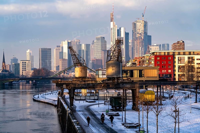 The skyline of Frankfurt am Main, skyscrapers of the banking district, historic harbour cranes at the Wesel shipyard, wintry morning, Hesse, Germany, Europe