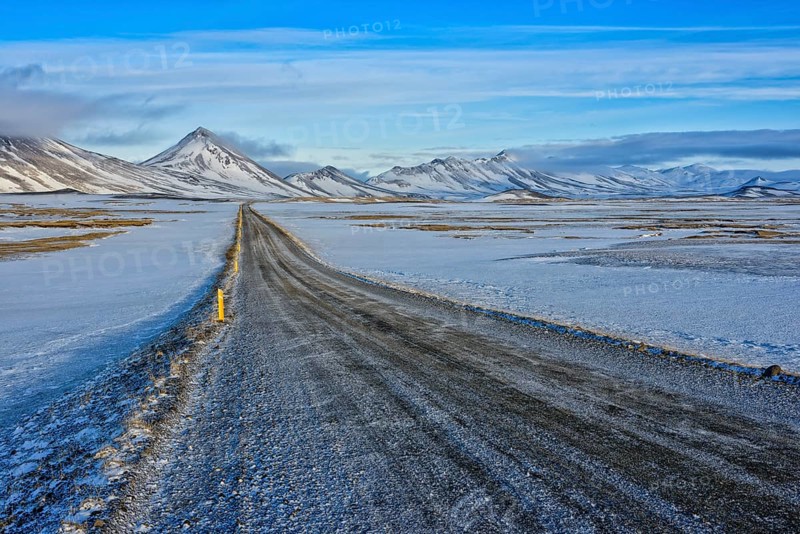 Ringroad no. 1 near farm Mödrudalur, gravel road, snowcovered mountain range between lake Myvatn und town Egilsstadir, Iceland, Europe