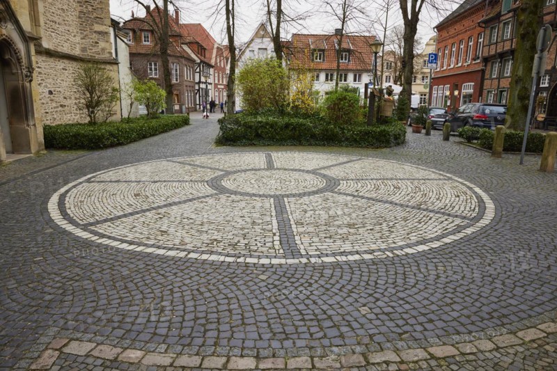 Rosette of white cobblestones at St Laurentius Church with historic houses and trees in the background in Warendorf, Warendorf district, North Rhine-Westphalia, Germany, Europe