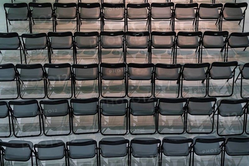 Folding chairs, at an event, still unused, in a row