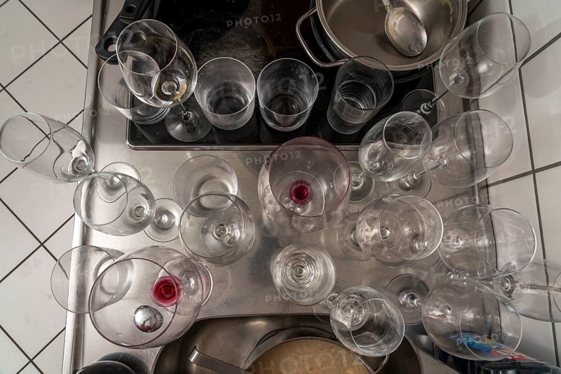 Kitchen after a big dinner, cooking party, dishes, dirty glasses, cooking utensils on the sink, waiting to be washed up