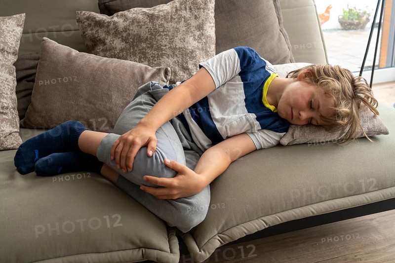 Growing pains in children, boy, 10 years old, has pain in his leg, symbolic picture