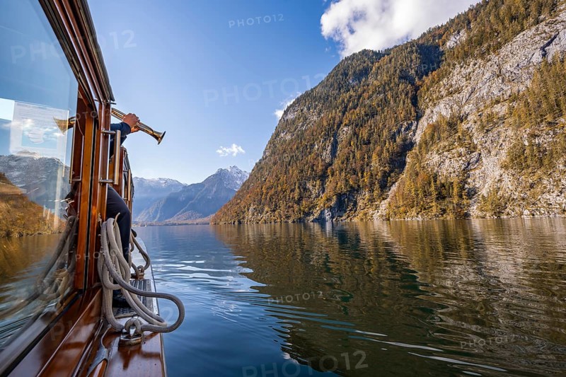 A trumpet is played on the echo wall of a tourist boat, Königssee, autumnal mountain landscape reflected in the lake, Berchtesgaden National Park, Berchtesgadener Land, Upper Bavaria, Bavaria, Germany, Europe