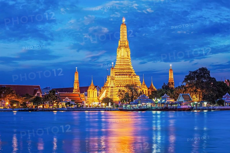 Buddhist temple Wat Arun (Wat Arun Ratchawararam Ratchawaramahawihan, Temple of Dawn) famous tourist landmark illuminated in the evening. Bangkok, Thailand, Asia