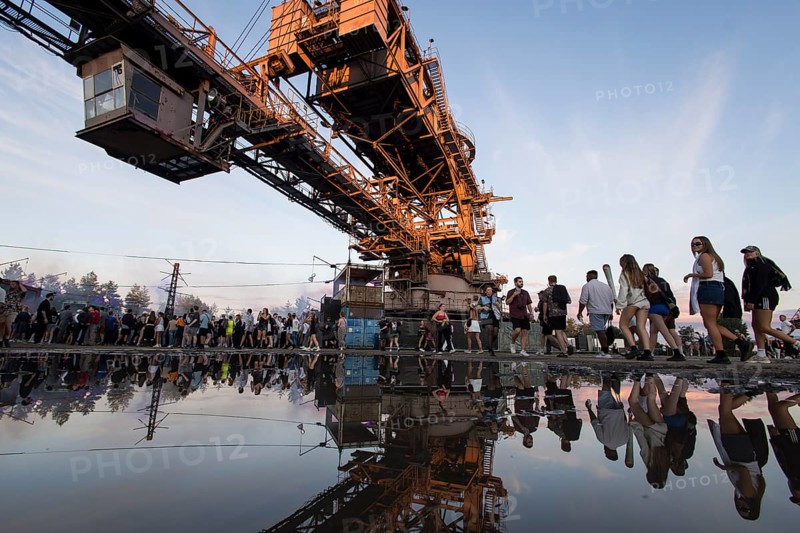 An open-cast mining excavator is reflected in a puddle at the Melt Festival in Ferropolis on 13 July 2024. After a total of 27 years, the festival will take place for the last time in 2024