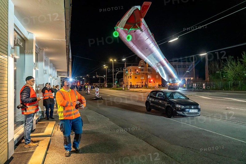 Transport of a 68 metre long, 22 tonne blade of a wind turbine, here in Schwelm, onlookers, with a self-propelled Blade-Lifter vehicle, over a 40 km long route, over 2 nights, in the Bergisches Land, through towns, villages, over country roads, narrow through roads, to the construction site of the wind turbine near Hagen, North Rhine-Westphalia, Germany, Europe