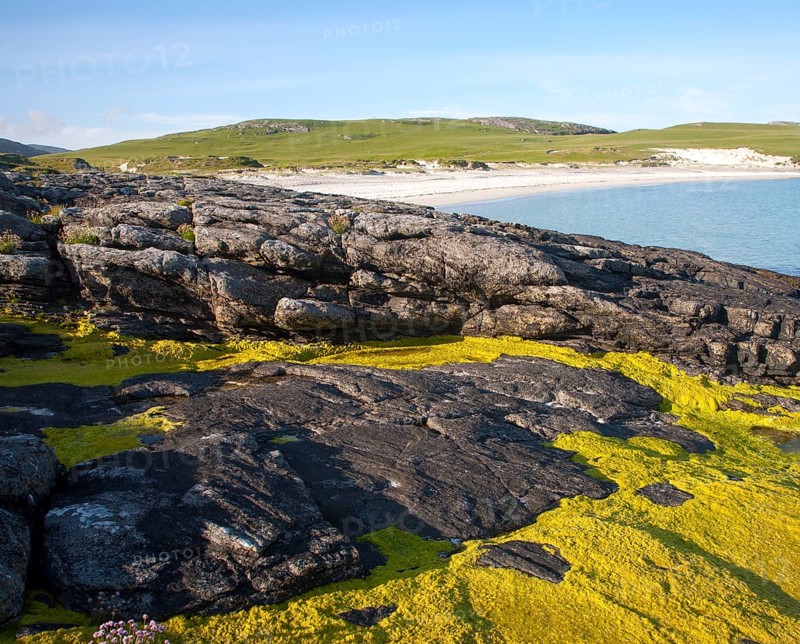 Rocky headland and sandy beach at Bagh a Deas, South Bay, Vatersay island, Barra, Outer Hebrides, Scotland, UK