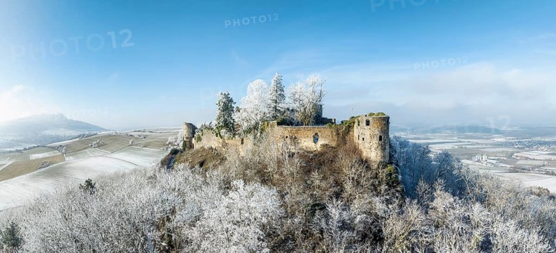 Aerial view of the snow-covered Hegau volcano MÃ¤gdeberg, with remains of a castle wall, surrounded by frosty trees in a winter landscape, district of Constance, Baden-Württemberg, Germany, Europe
