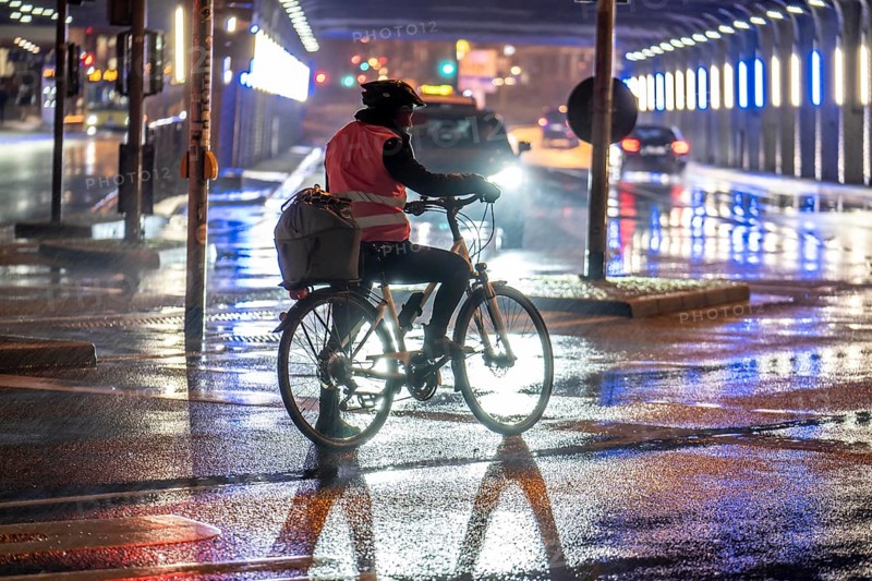Street at the central station, cyclist, rainy weather, city centre, in the evening, Essen, North Rhine-Westphalia, Germany, Europe