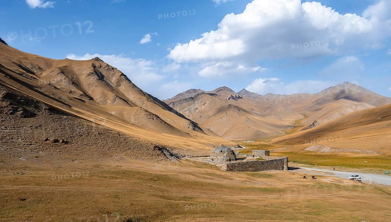 Historic caravanserai Tash Rabat from the 15th century, in the evening light with golden hills, Naryn region, Kyrgyzstan, Asia