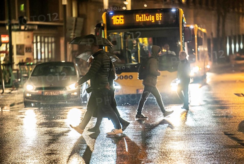 Passers-by at a pedestrian crossing, at the main railway station, rainy weather, city centre, in the evening, Essen, North Rhine-Westphalia, Germany, Europe