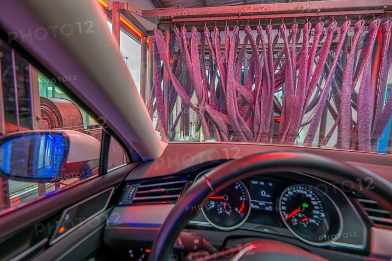 Car in an automatic car wash, car wash tunnel, vehicle drying after washing with warm compressed air and drying cloths