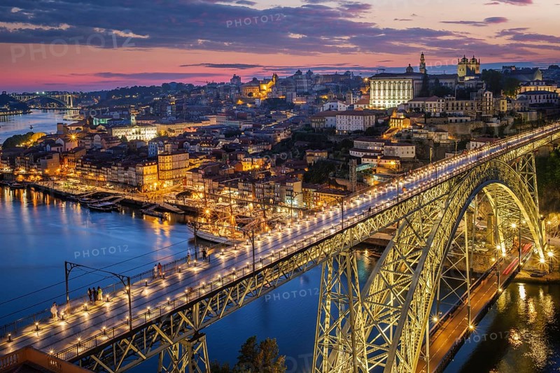 View of illuminated Porto city and Douro river and Dom Luis bridge I from famous tourist viewpoint Miradouro da Serra do Pilar in evening twilight. Porto, Vila Nova de Gaia, Portugal, Europe