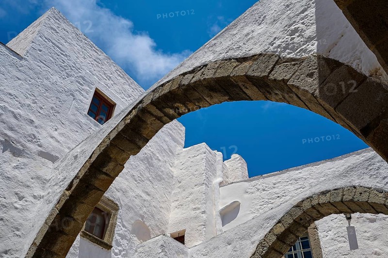 View upwards of arches and white walls against a blue sky, part of a historic monastery, Inside the monastery, Agiou Theologou Monastery, Chora, Patmos, Dodecanese, Greek Islands, Greece, Europe