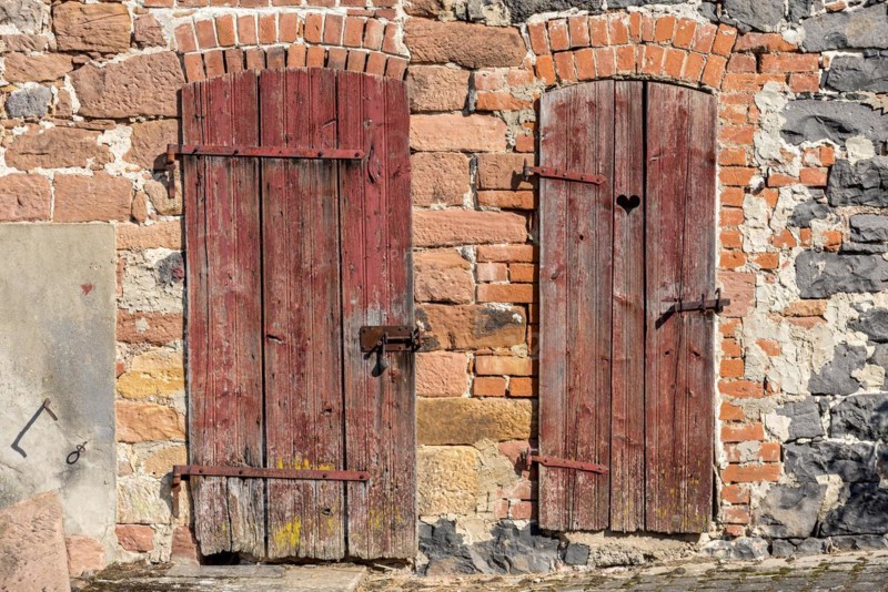 Weathered wooden doors to stable and loo, with heart, façade made of sandstone, natural stone, brick, cement, historic farmhouse around 1800, idyllic, romantic, Nidda, Vogelsberg, Wetterau, Hesse, Germany, Europe