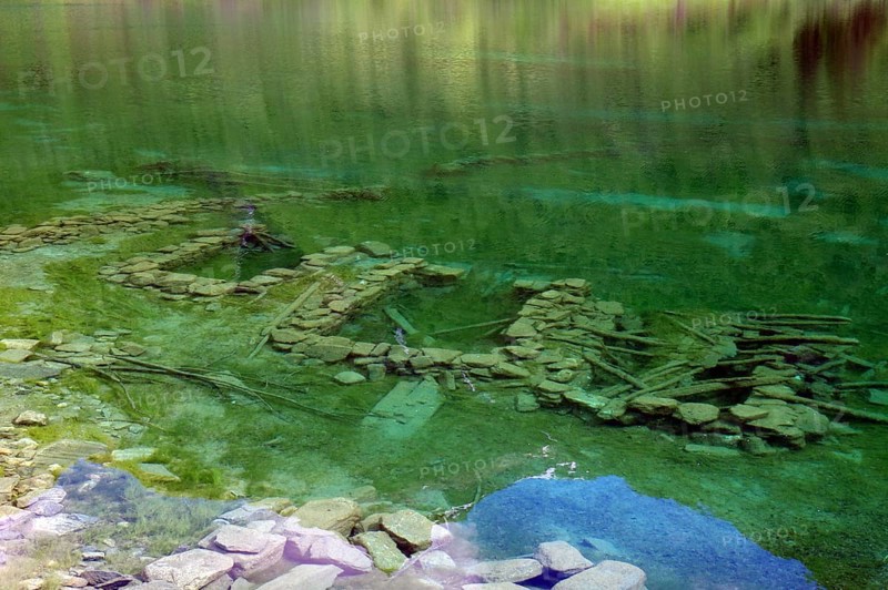 Clear, green water with visible stones and ruins underneath, surrounded by natural landscape, foundation walls of a sunken village, Nörangsdalen, Norway, Europe