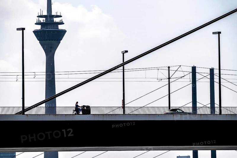 Oberkassler Bridge over the Rhine near Düsseldorf, in front, behind the Rheinknie Bridge, cargo bike cyclist, Rhine Tower, North Rhine-Westphalia, Germany, Europe