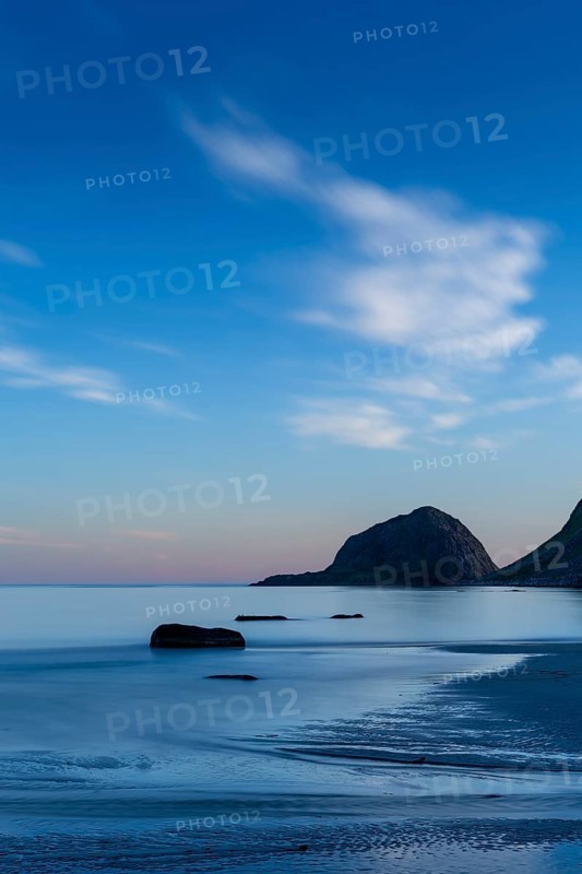 Seascape on the beach at Haukland. The sky is blue. At night at the time of the midnight sun in good weather. Early summer. Long exposure. Haukland Beach, Haukland, Vestvagoya, Lofoten, Norway, Europe