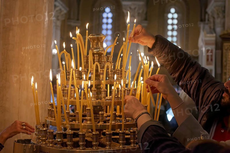 Several hands put burning candles into a candlestick, Greek Orthodox Cathedral of the Annunciation, Mitropolis, Athens, Greece, Europe