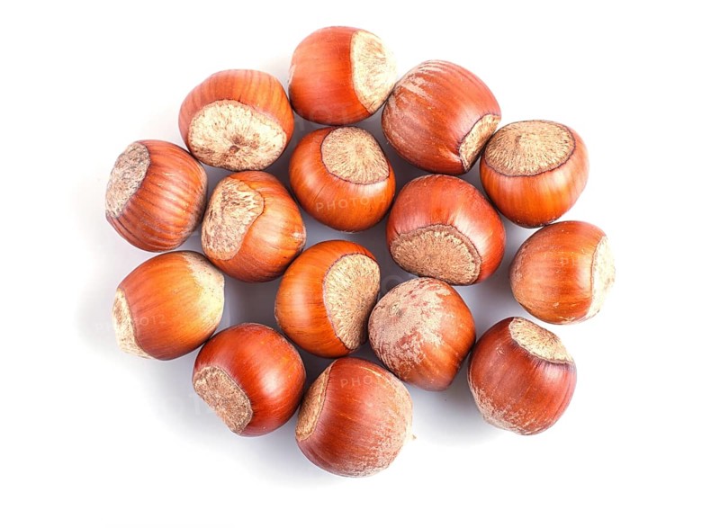 Pile of hazelnuts with shell isolated on white background. top view