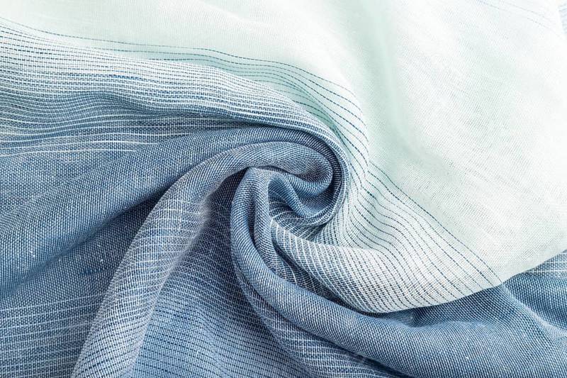 Fragment of blue linen tissue. Top view, natural textile background and texture. wave concept, abstract, spiral