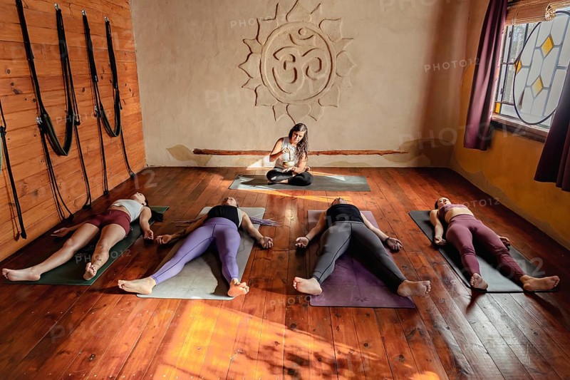 Yoga class lying down in in Corpse pose. Shavasana at end of class. Final pose of yoga class deep restoration, body and mind relaxation concept