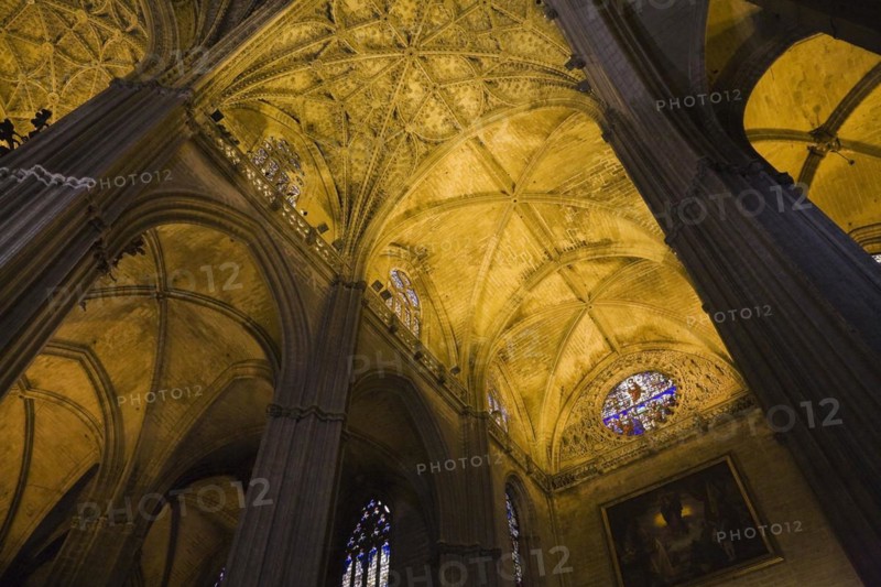Architectural details on ceiling and stained glass rose window in Interior of The Cathedral of Saint Mary of the See or Seville Cathedral, Seville, Spain, Europe