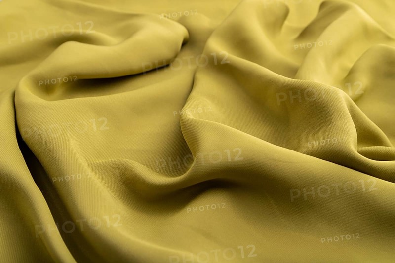 Fragment of green olive silk tissue. Side view, natural textile background and texture. wave concept, abstract