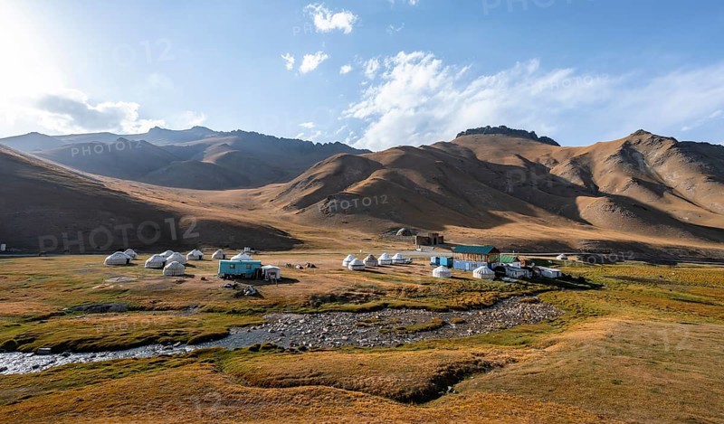 Yurts and historic caravanserai Tash Rabat from the 15th century, with yellow hills, Atbashy district in the Naryn region, Kyrgyzstan, Asia