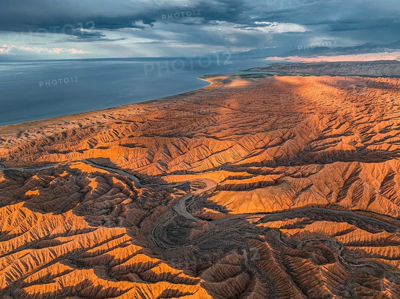 Landscape of eroded hills, badlands at sunset, Issyk Kul Lake in the background, aerial view, Canyon of the Forgotten Rivers, Issyk Kul, Kyrgyzstan, Asia