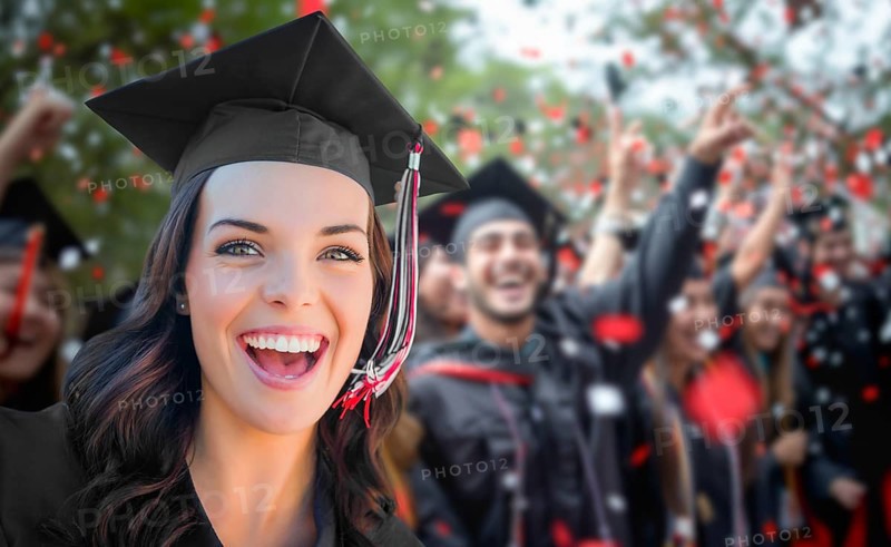 Young female graduate celebrating her graduation with her fellow classmates outdoors
