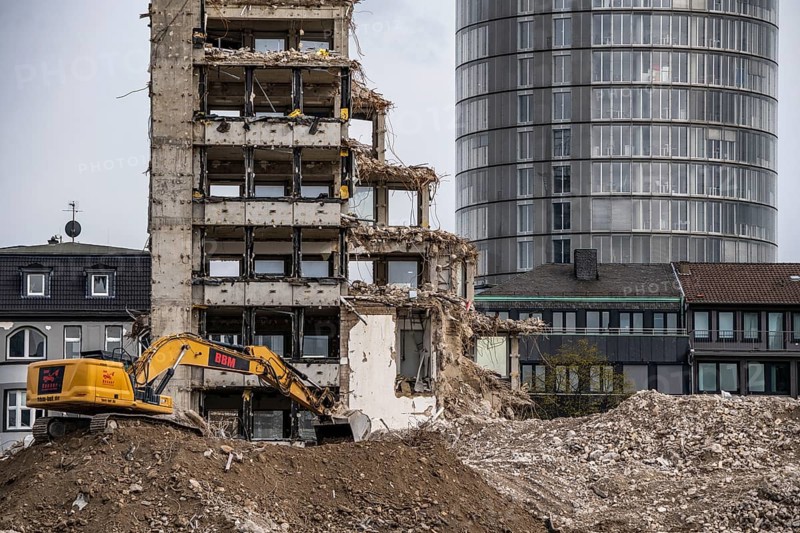 Demolition of the former RWE building complex, in the city centre, on the A40 motorway in Essen, excavator working on the piles of rubble, in the background the RWE Tower, North Rhine-Westphalia, Germany, Europe