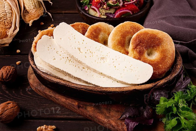 Mchadi, corn tortillas, traditional Georgian dish, corn bread, with Imeretian cheese, homemade, no people, on a wooden table