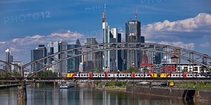 Main with regional railway on the Deutschherrnbrücke and a cargo ship in front of the skyline of Frankfurt am Main, Hesse, Germany, Europe