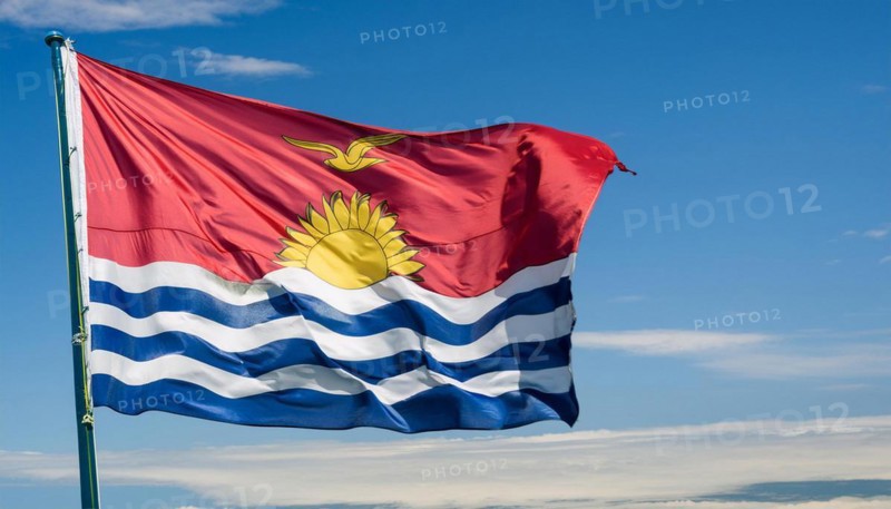 The flag of Kiribati, Polynesia, flutters in the wind, isolated against a blue sky