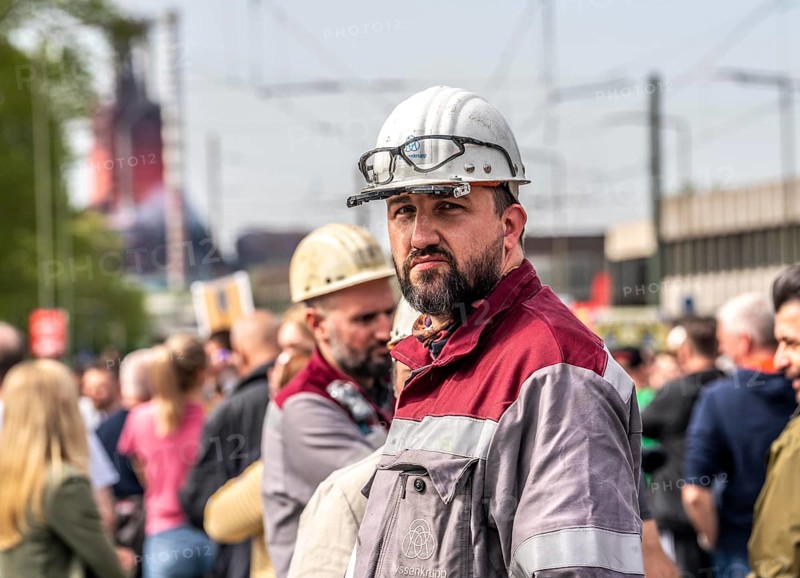 Steelworkers at a demonstration in front of the headquarters of ThyssenKrupp Steel Europe in Duisburg, against massive job cuts, after the participation of a foreign investor in the group, in the background the blast furnaces 8 and 9, Duisburg North Rhine-Westphalia, Germany, Europe
