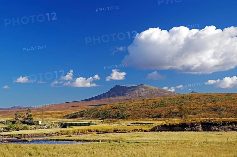A mountain rises above a peaceful meadow under a clear blue sky, autumn, October, Highlands, railway line Inverness to Kyle of Lochals, Scotland, Great Britain