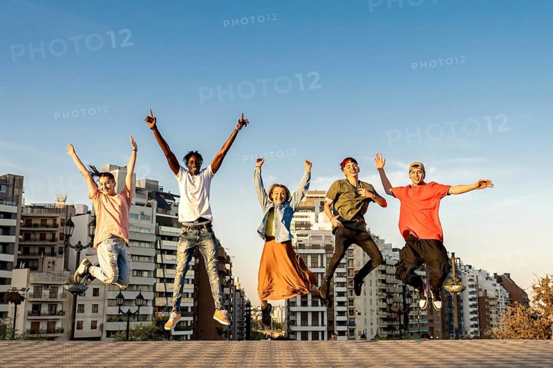 Group of young beautiful multiethnic man and woman friends having fun jumping outdoor in the city, happiness, friendship, teamwork concept