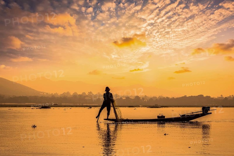 Myanmar travel attraction landmark, traditional Burmese fisherman sihouettes at Inle lake on sunset, Myanmar famous for their distinctive one legged rowing style