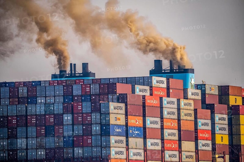 Container freighter Madison Maersk smoking chimneys of the ship's diesel engines, Maasvlakte 2, Rotterdam, Netherlands