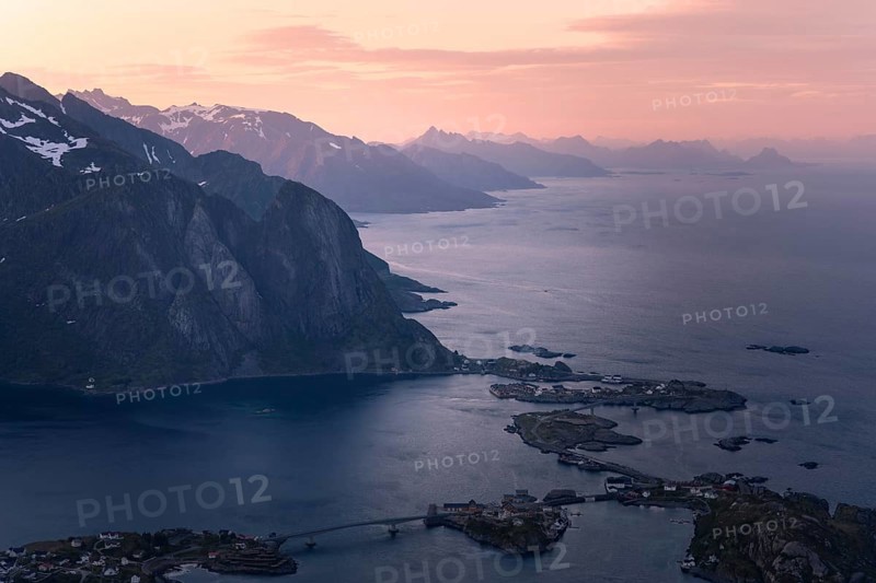 View from Mount Reinebringen to the village of Reine, with Mount Lilandstinden on the left. More mountains and the sea. At night at the time of the midnight sun in good weather. Early summer. Reine, Moskenesoya, Lofoten, Norway, Europe