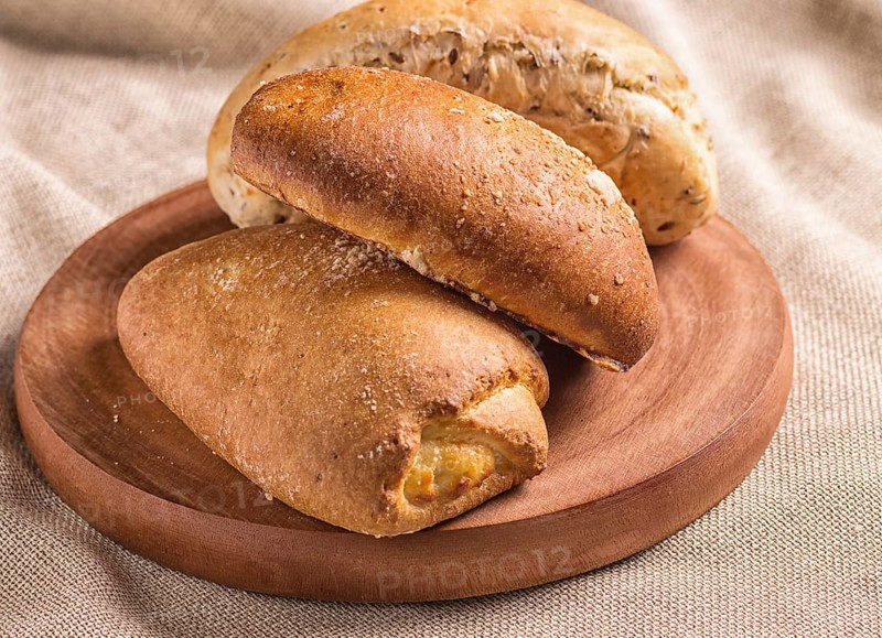 Sweet buns on a wooden board and linen tablecloth